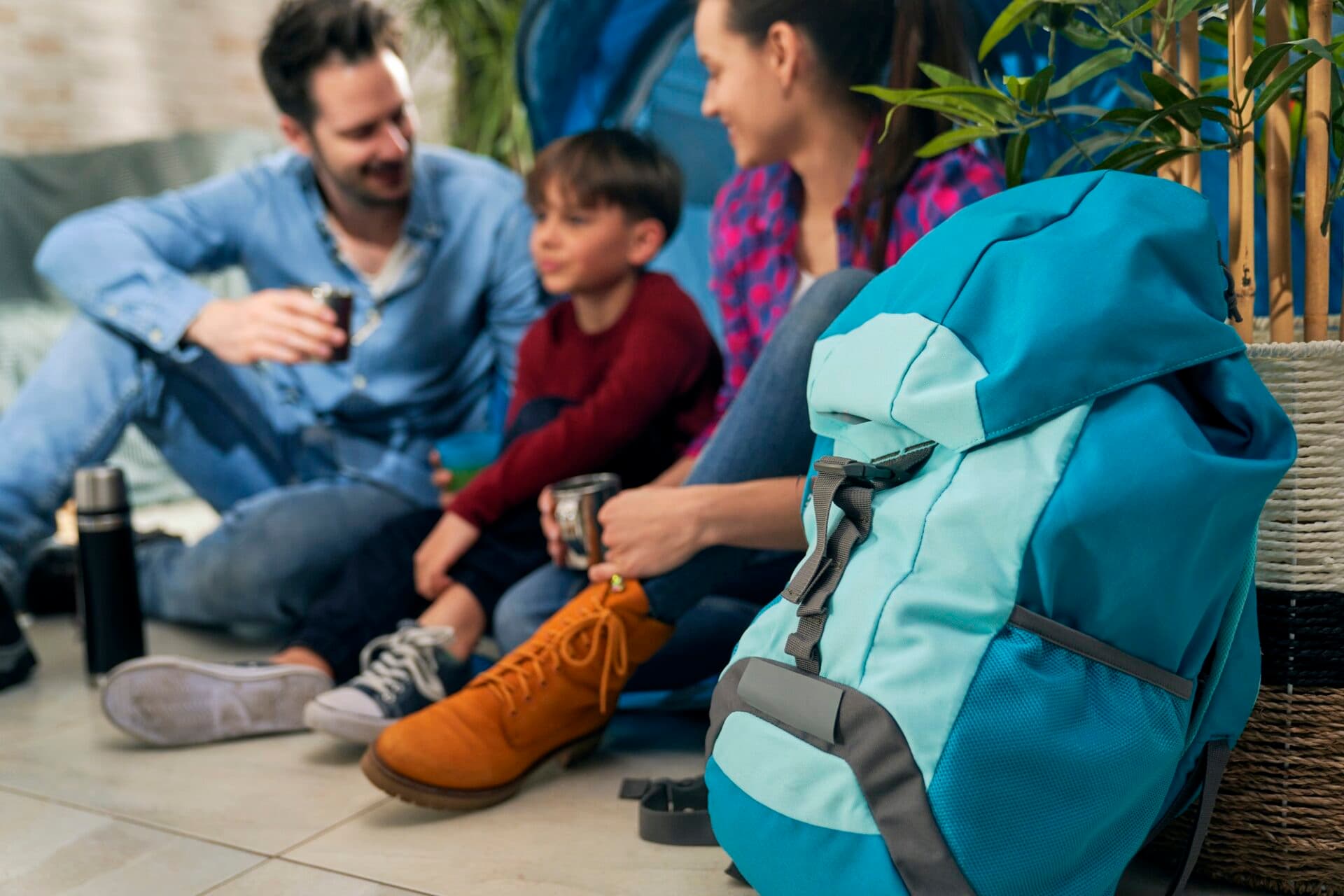 Close up of backpack and family while camping indoors