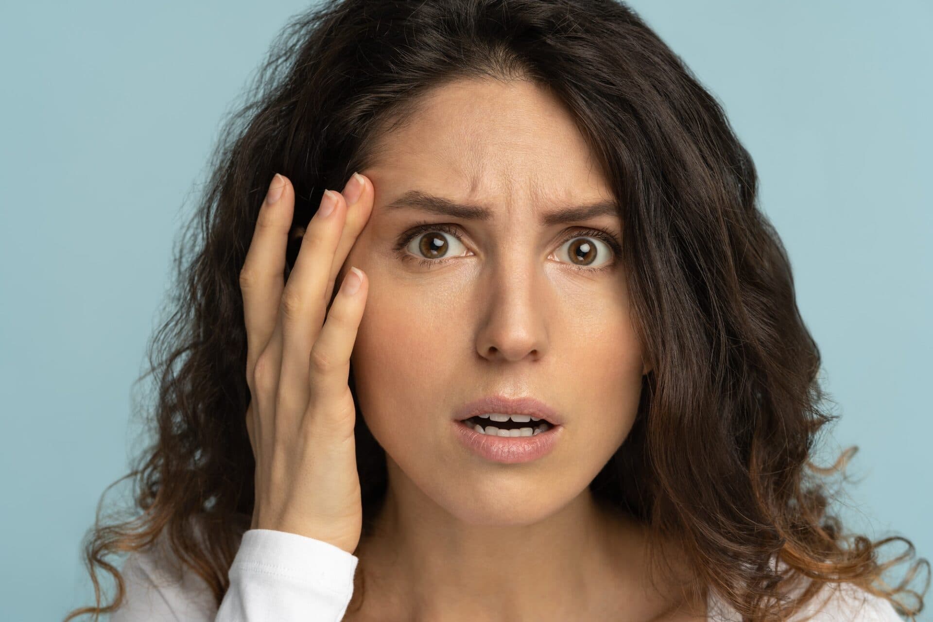 Worried woman has signs of aging skin, checking crows feet troubled with wrinkles on face, isolated