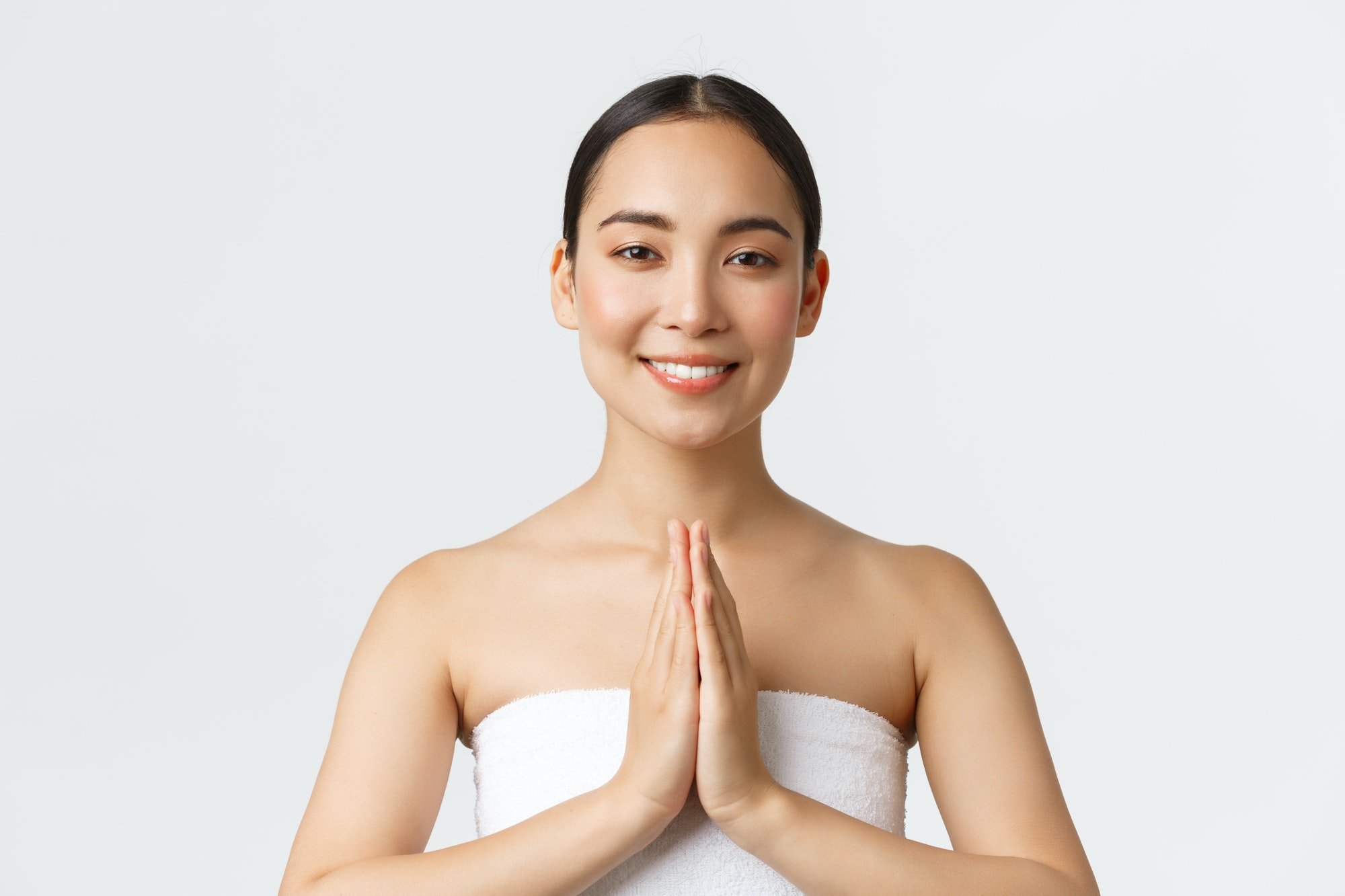 Beauty, cosmetology and spa salon concept. Tender asian girl in towel smiling friendly camera and