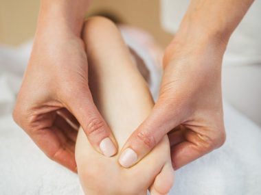 Young woman getting foot massage in therapy room